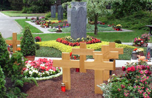 Beisetzung mit aufgestellten Holzkreuzen